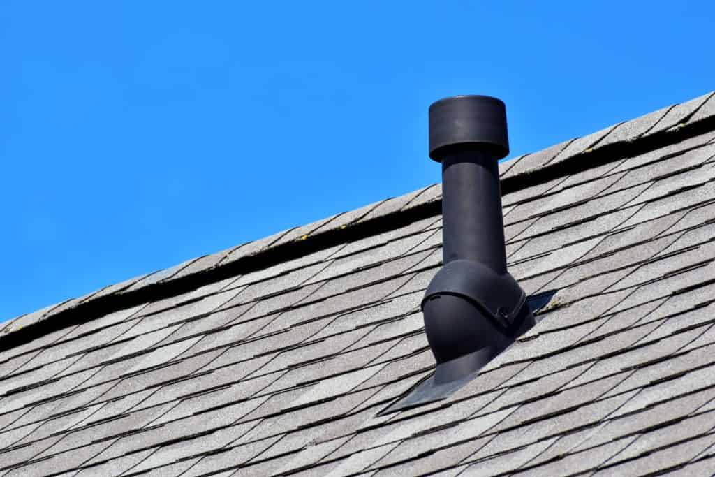 A black roof boot on a black shingle roofing