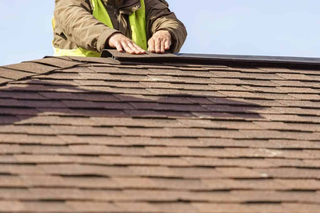A roofer installing the ridgeroll of the house