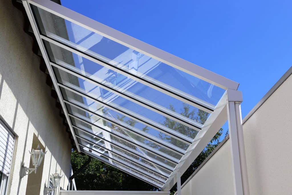 A white aluminum colored patio with glass roofing