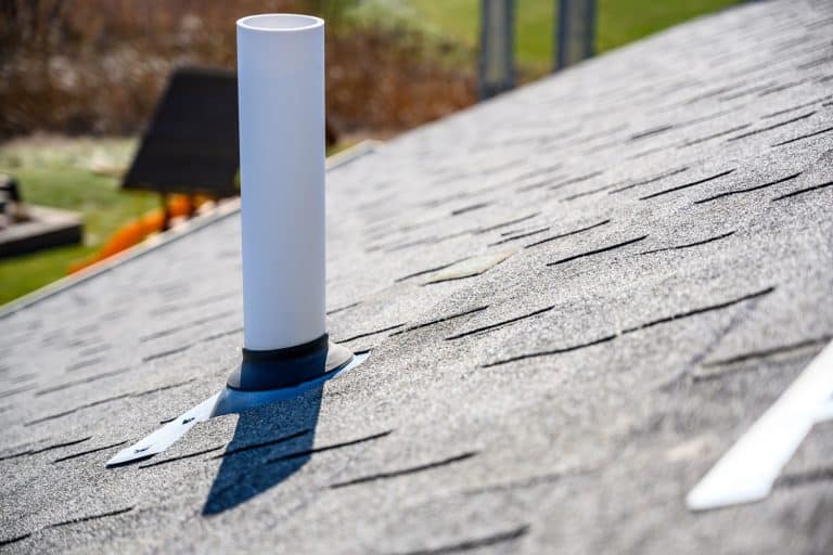 A white roof boot on a gray shingle roofing, How Long Do Roof Vent Boots Last?