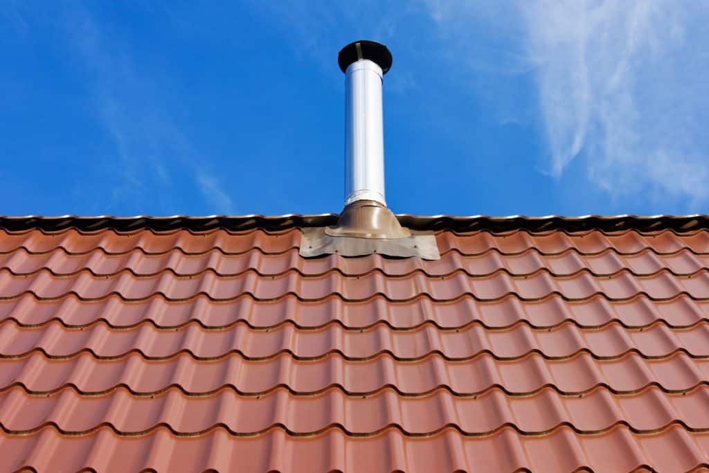 A white roof boot on a red metal roof sheet