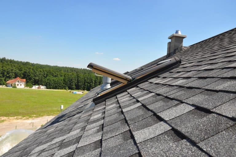 An asphalt shingles roof with open attic skylight window, How Long Does an Asphalt Shingle Roof Last