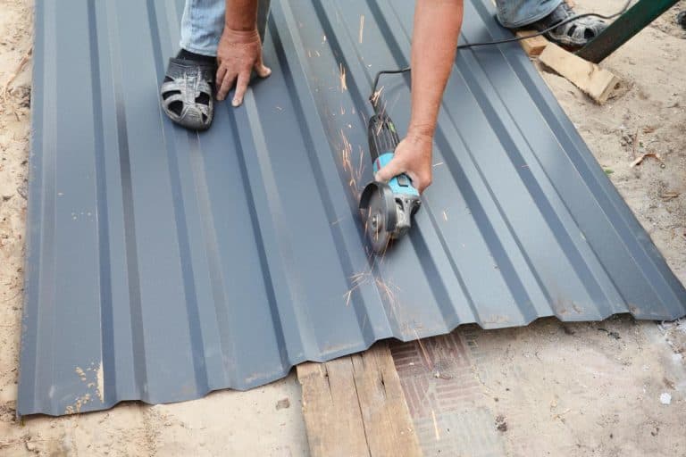 A contractor is cutting corrugated metal roof sheet using an angle grinder to cover the rooftop of the house, How to Cut Metal Roofing