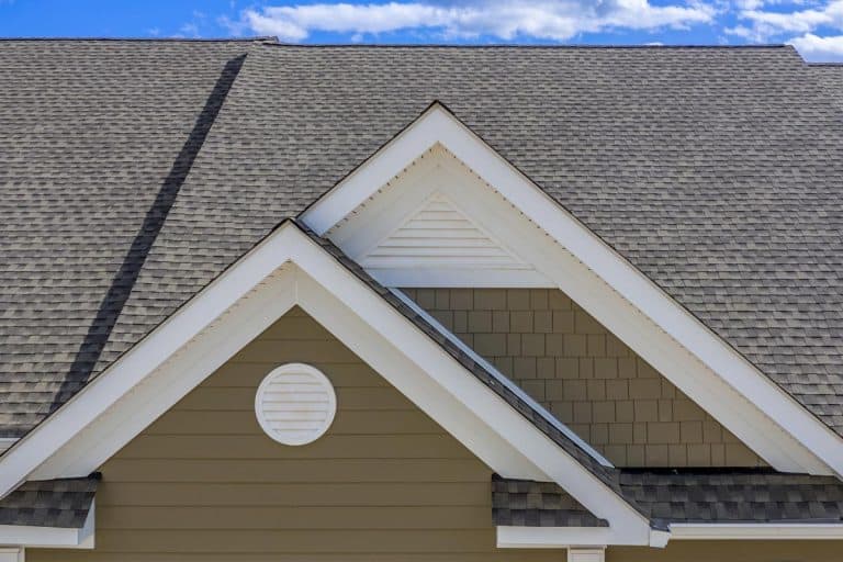 An elegant colonial white round gable vent on a beige shake and shingle siding roof on a luxury town home, How long does a presidential roof last?