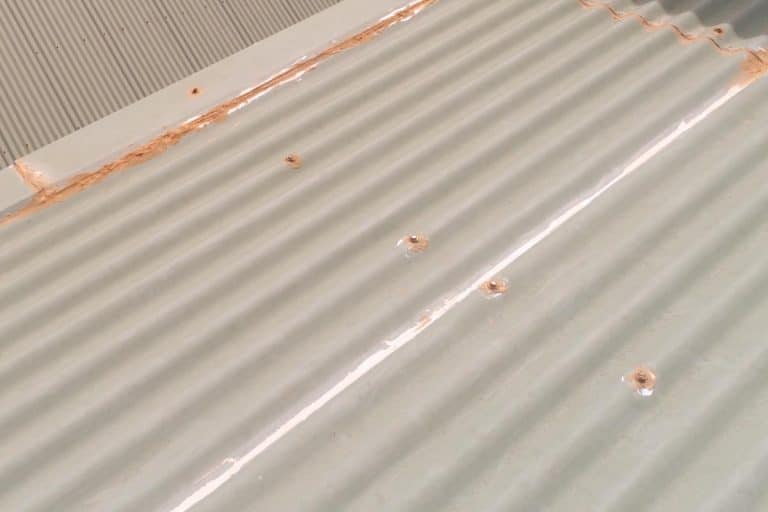 A green corrugated iron roof with retaining screws, How to remove silicone sealant from a metal roof?