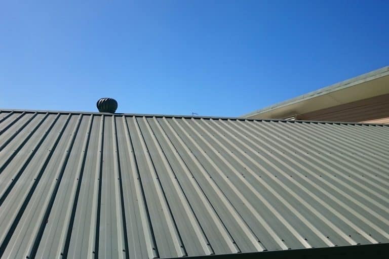 Old and slowly degrading green metal roofing with a vent on top, What Is the Best Paint for an Old Metal Roof