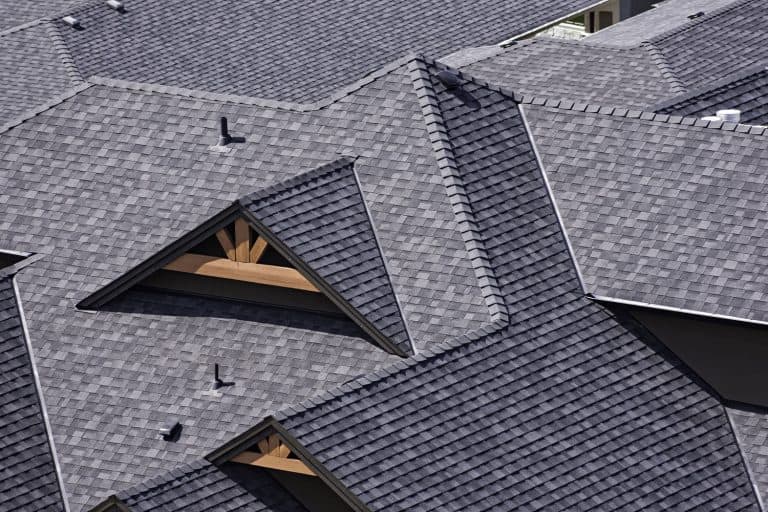 Rooftop in a newly constructed subdivision in Michigan showing asphalt shingles and multiple roof lines, How Long Does a Shingle Roof Last in Michigan