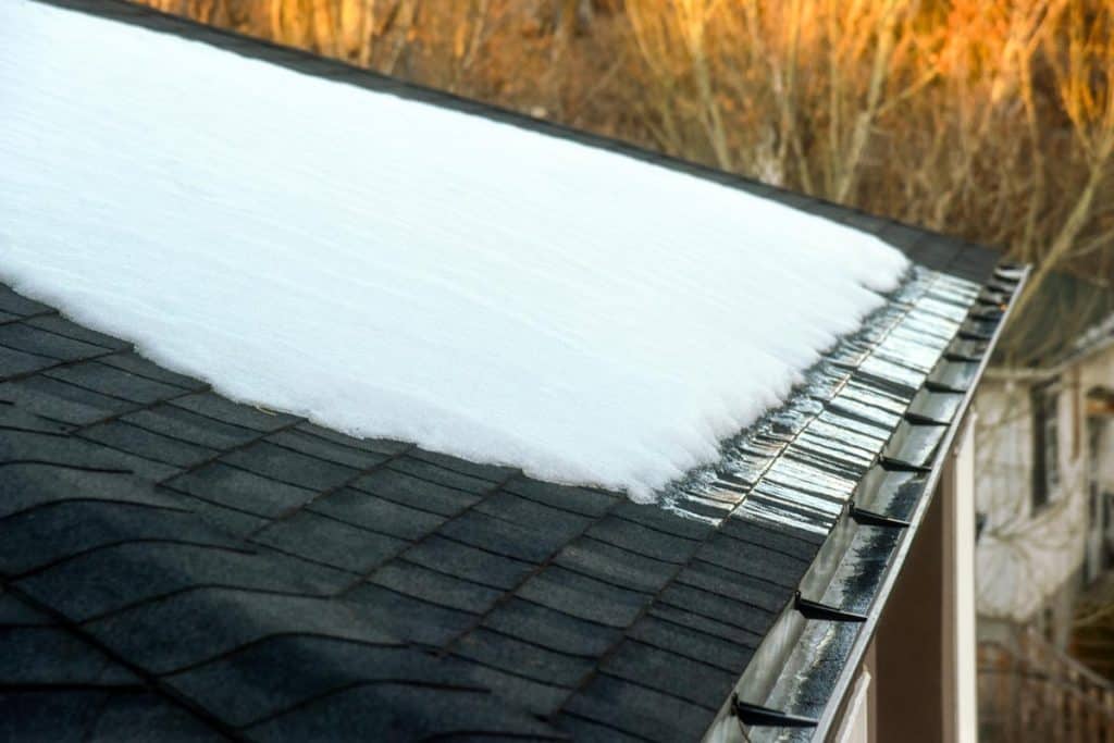 Snow melting on shingled roof with eavestrough