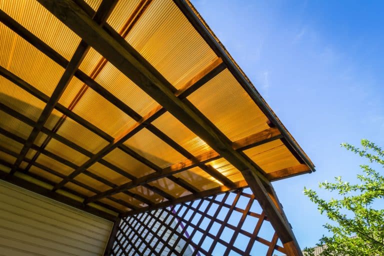 The roof of the veranda of orange polycarbonate on blue sky background, How to Stop Polycarbonate Roof Creaking