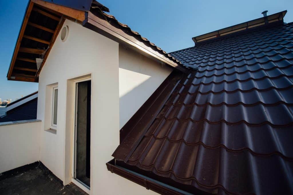 Tile roof of a two-story white cottage