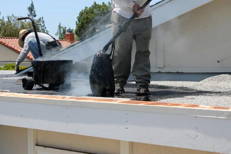 Workers use "Hot Mop" to lay down molten tar, asphalt sheets and pea gravel on a flat roof, Does Tar stop roof leaks?