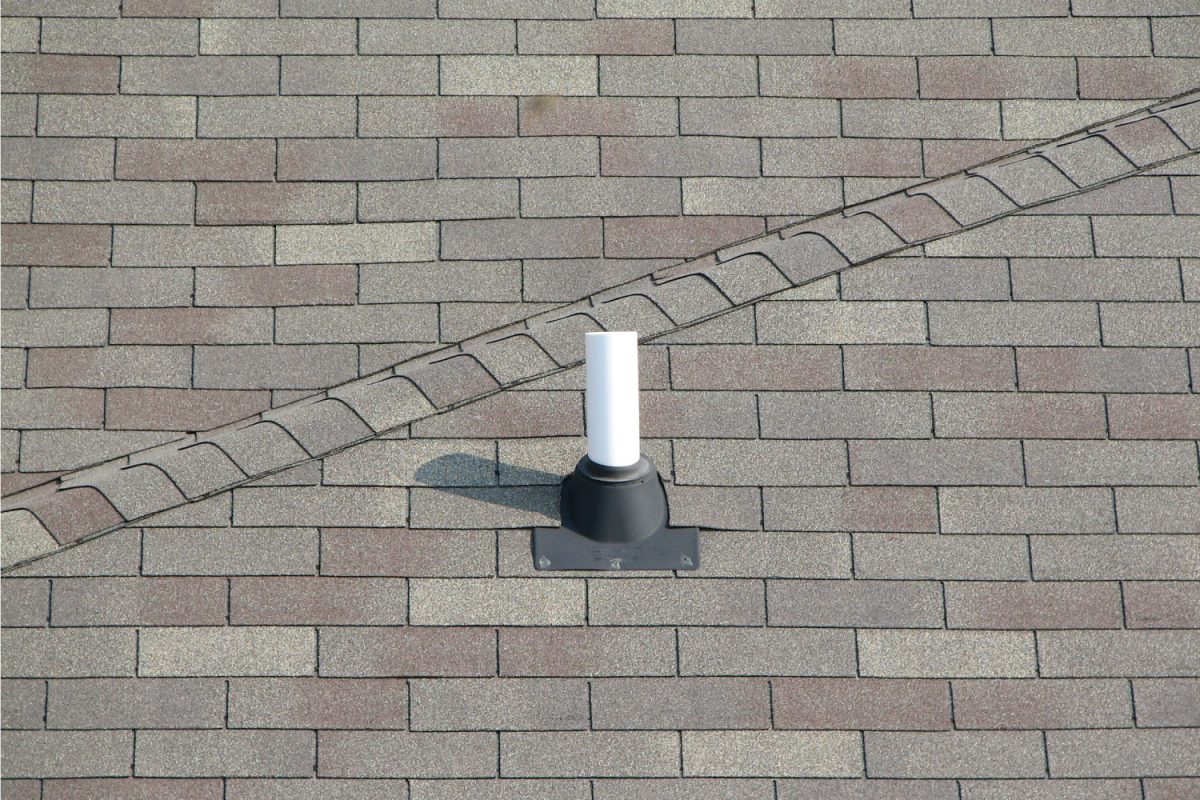 A PVC Roof Vent on the top of a home with standard gray shingles.