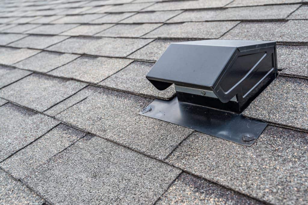 A black stainless steel metal roof vent of a shingle roofing