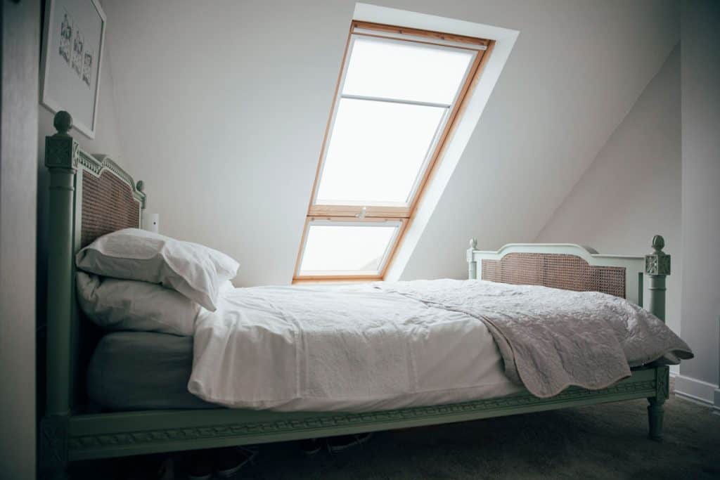 A double bed in an attic under a roof window