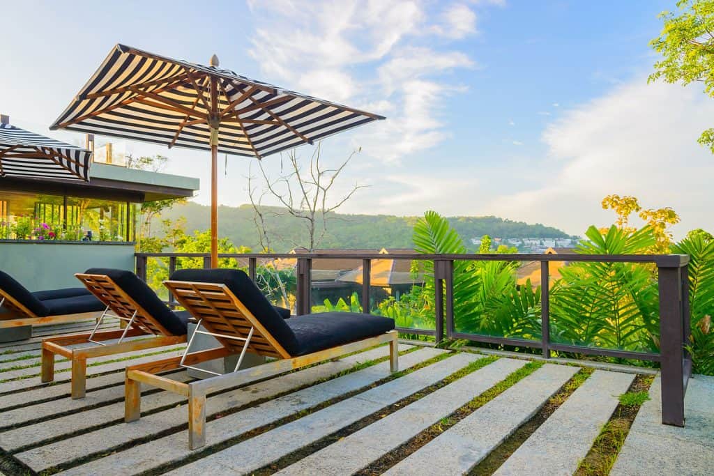 A gorgeous luxurious deck with benches and umbrella for a gorgeous view