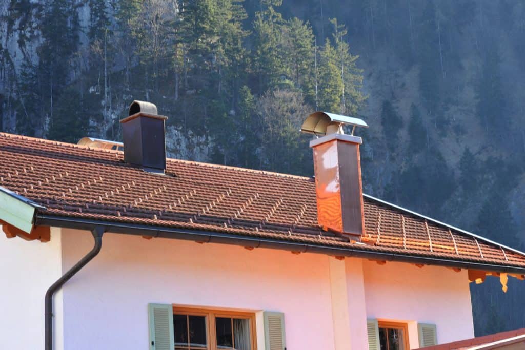 A two story house with copper roofing at a mountainous area