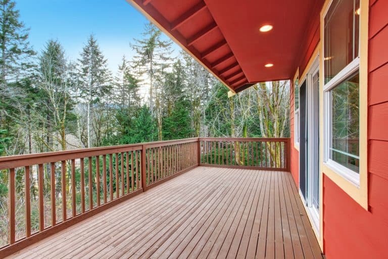 A wooden deck with an angled roof painted in red, Can My Deck Support A Roof?