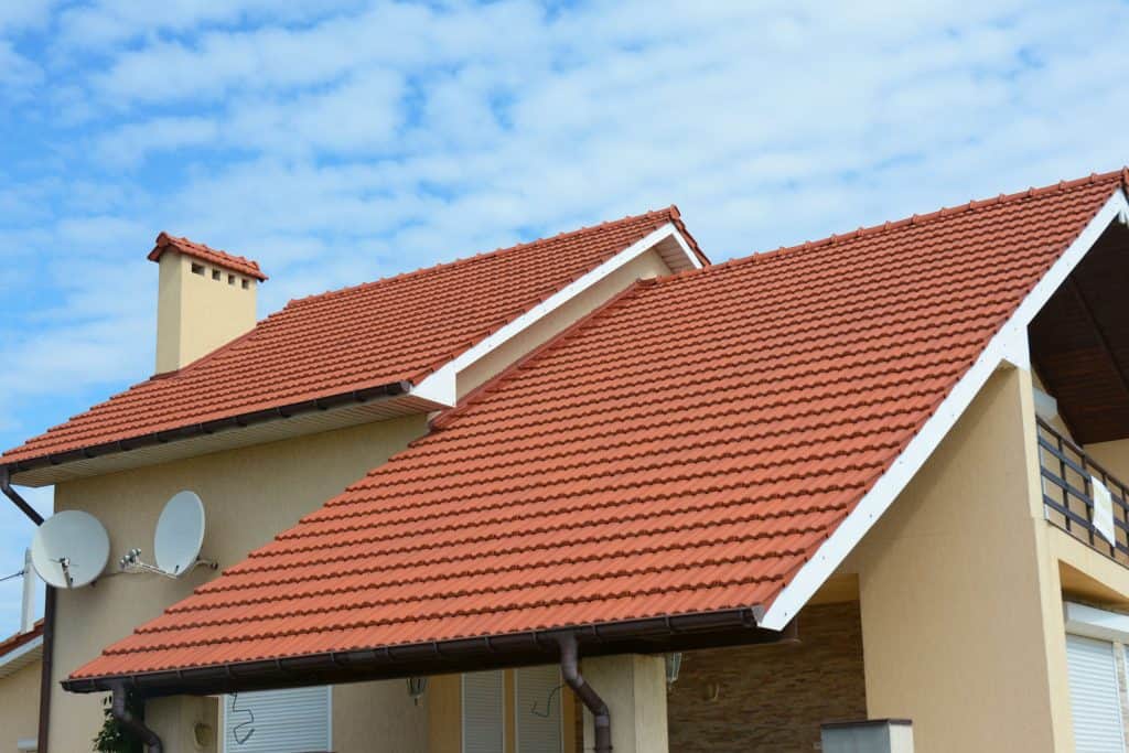 Clay tile roofing with brown metal gutters at a two story florida home