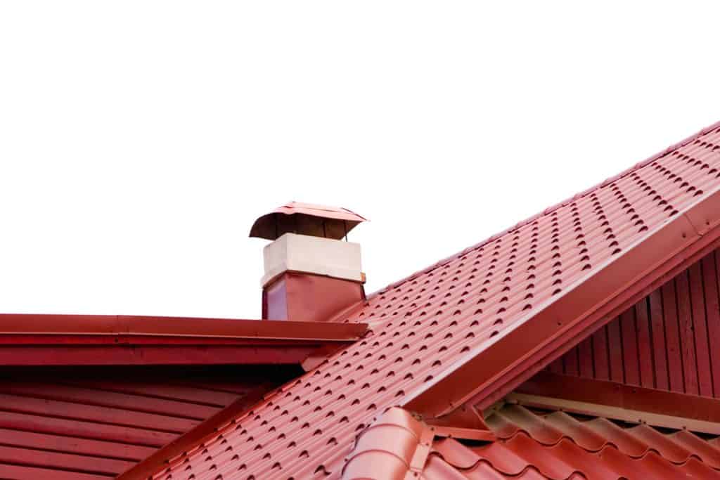 Dark red colored roofing sheets with ridge vents of a small house