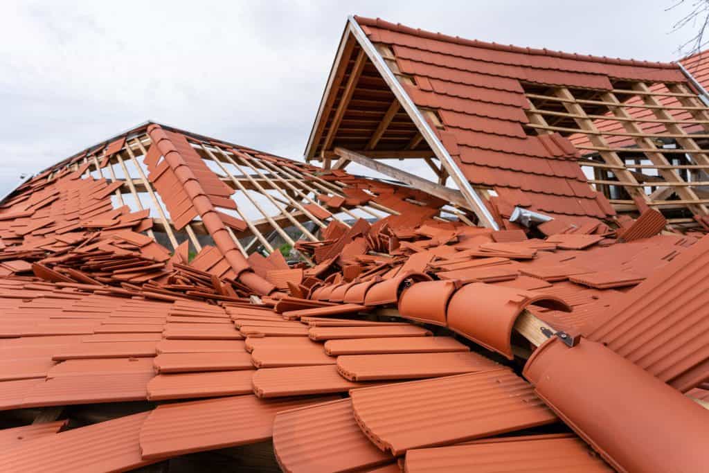Heavily damaged clay tile roofing due high winds or storm