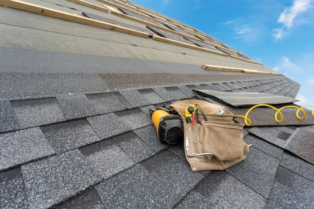 Installing roof shingles on a new house in a new roof