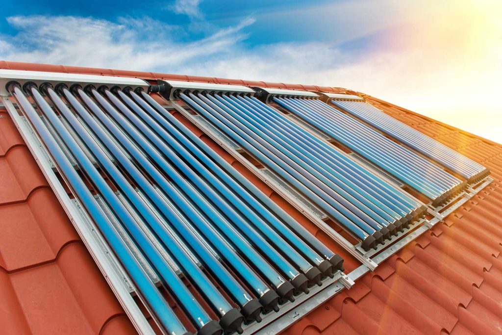Solar water heating system on red roof of the house