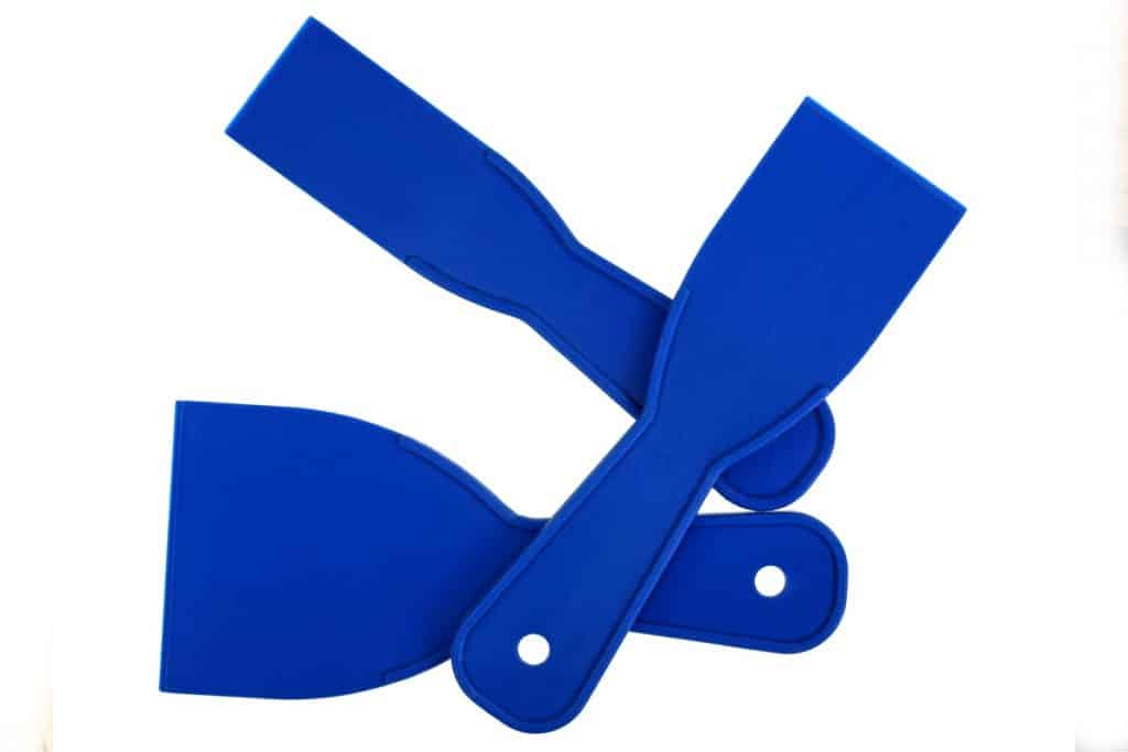 Three blue plastic putty knives