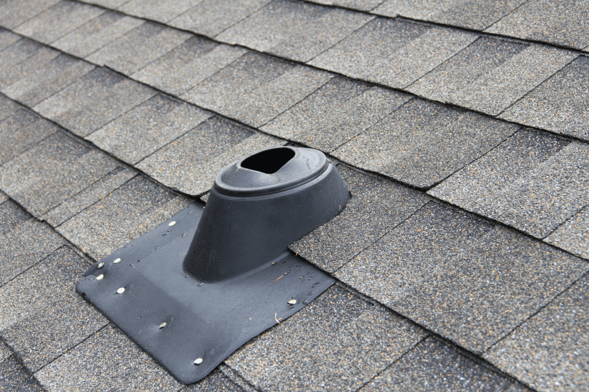 asphalt shingled house roof, showing the vent stack cover (vent pipe cover) used to allow the sanitary drain vent to be exhausted through the roof