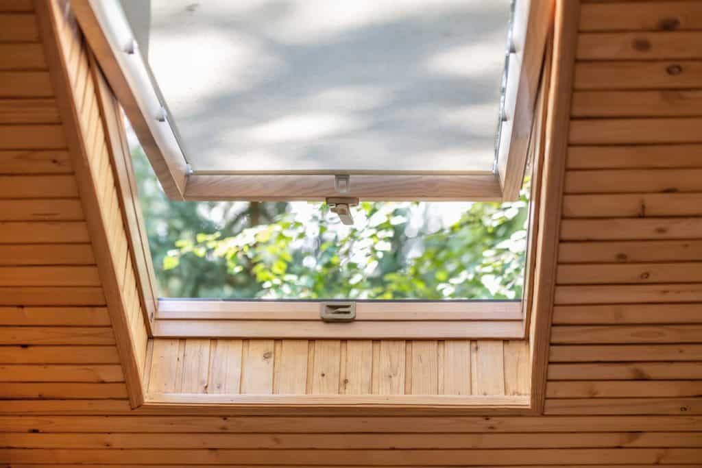 roof window with blinds or curtain in wooden house attic
