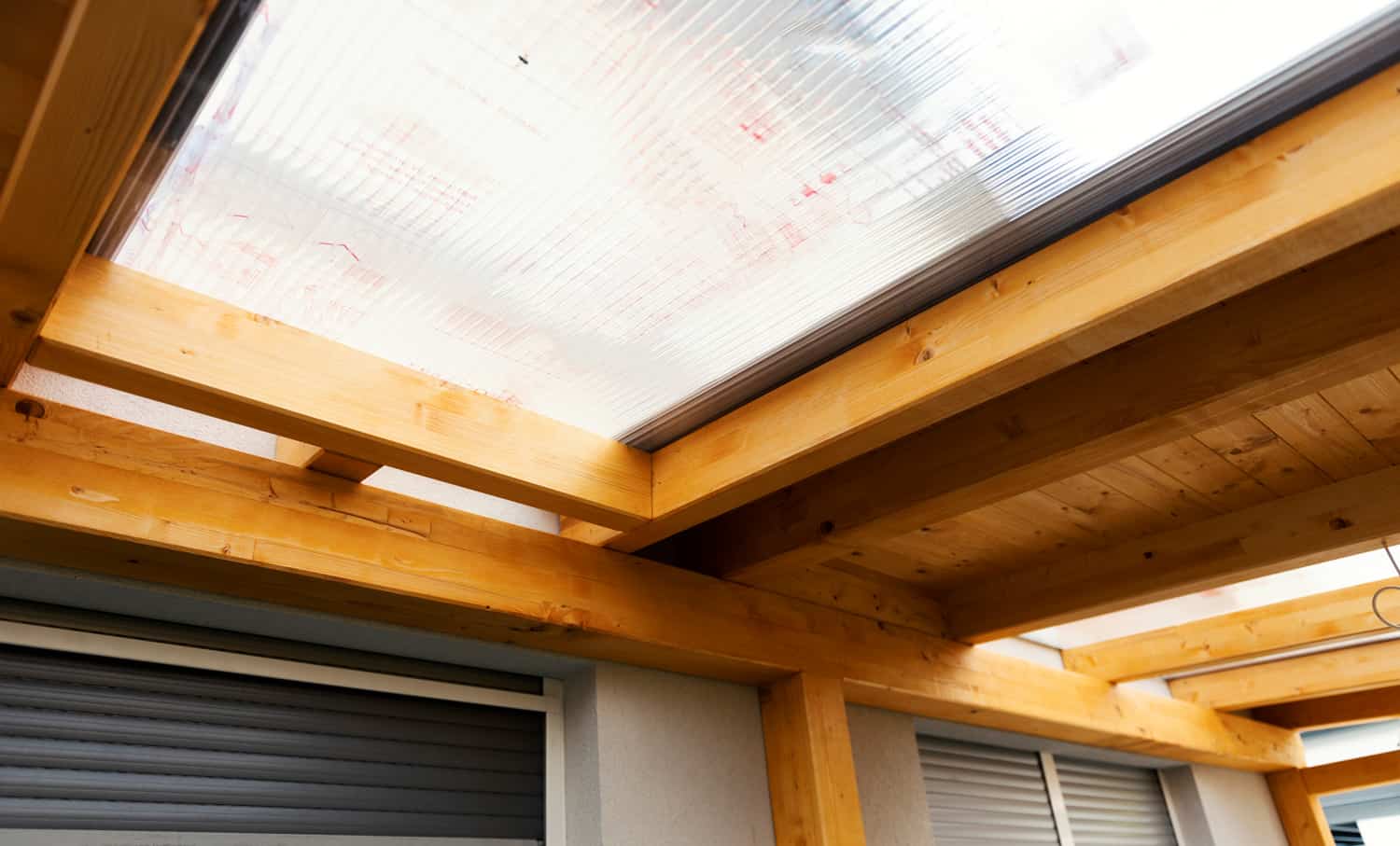 Massive wood beams roof structure covered with transparent polycarbonate sheet, wooden canopy