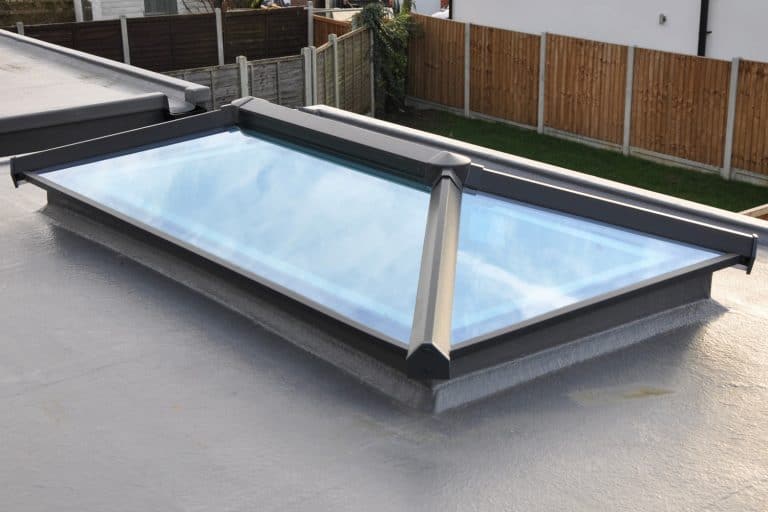 Modern glass roof lantern or light on contemporary grey flat roof in the rain - How To Repair A Leaking Roof Lantern